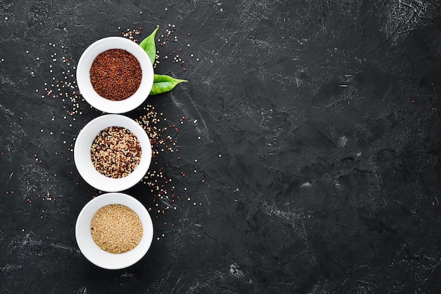 Set of quinoa Red white and brown quinoa On a black background Top view Free copy space