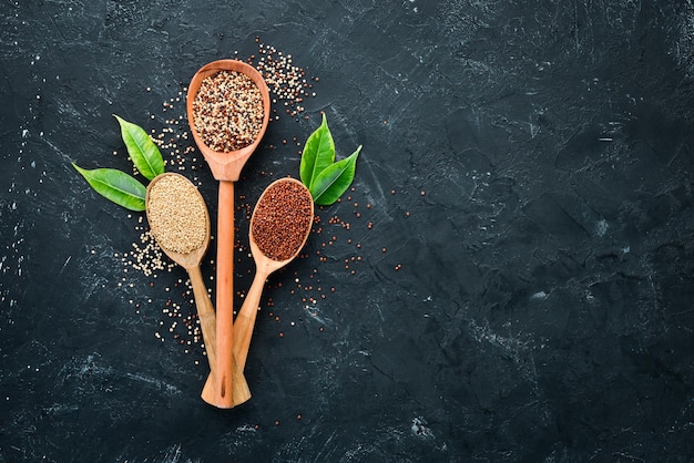 Set di quinoa quinoa rossa bianca e marrone su sfondo nero vista dall'alto spazio libero per la copia