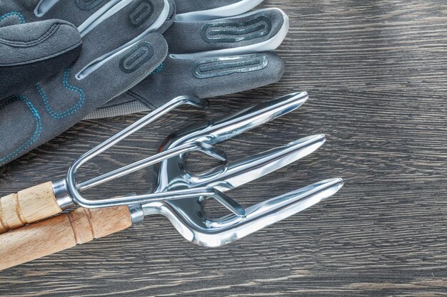 Set of rake trowel fork safety gloves on wooden board.