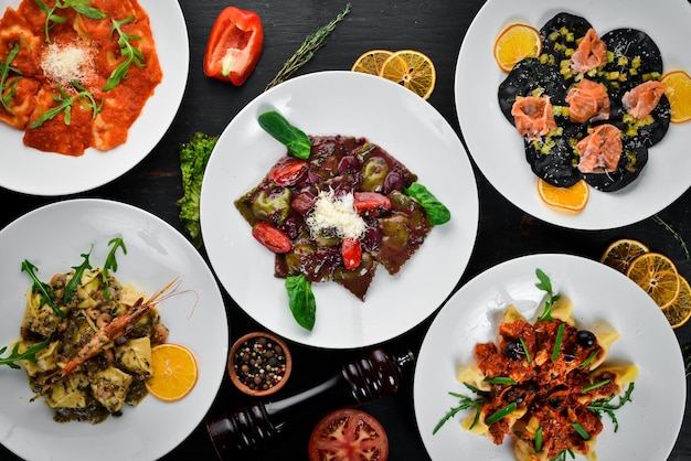 Foto un set di ravioli e gnocchi con carne e frutti di mare su uno sfondo di legno vista dall'alto spazio per la copia gratuito