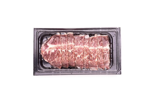 Set of raw sliced beef in black plastic tray isolated on white