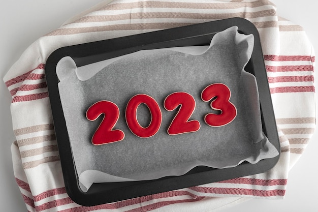 Set of red numbers 2023 ginger cookies on baking sheet Traditional Christmas gingerbread