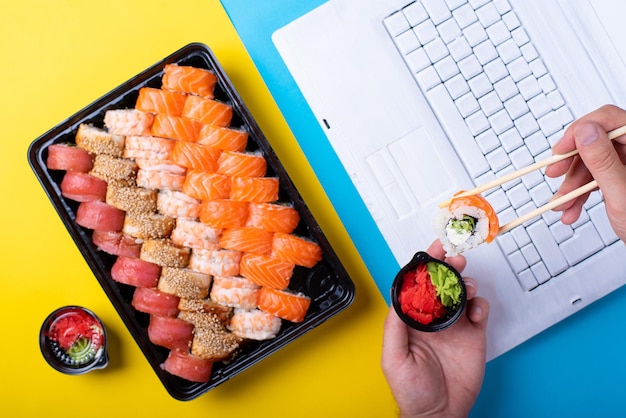 A set of rolls sushi and a laptop in the office japanese lunch at work