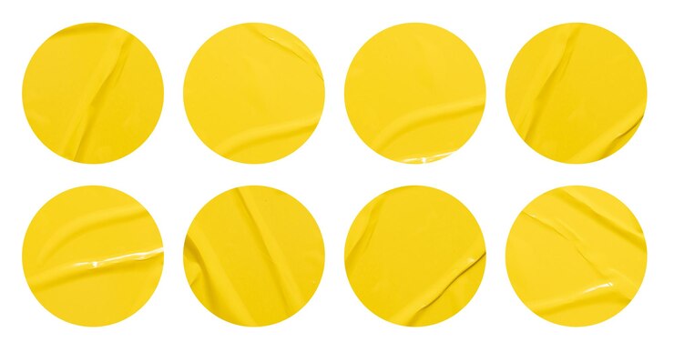 Photo set of round yellow paper stickers mock up blank tags labels isolated on white background with clipping path for design work