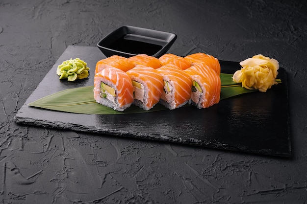 Set of salmon sushi rolls on stone board