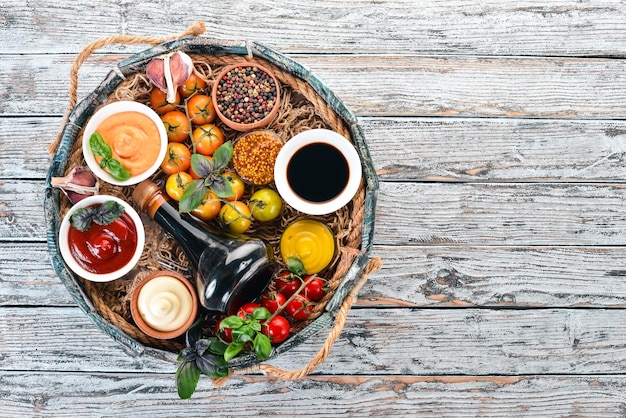 Set of sauces Ketchup mayonnaise mustard soy sauce barbecue sauce pepper and spices On a white wooden background Top view Free space for text