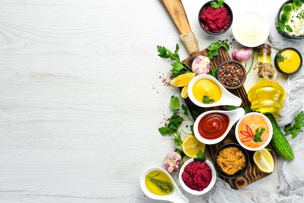 Set of sauces and spices on white wooden background Top view