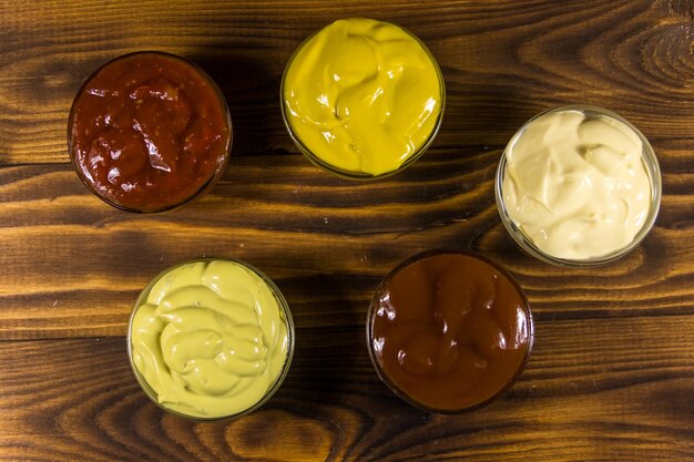 Set of sauces on wooden table. Top view