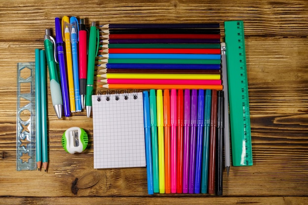 Set di forniture di cancelleria scolastica su una scrivania in legno torna al concetto di scuola