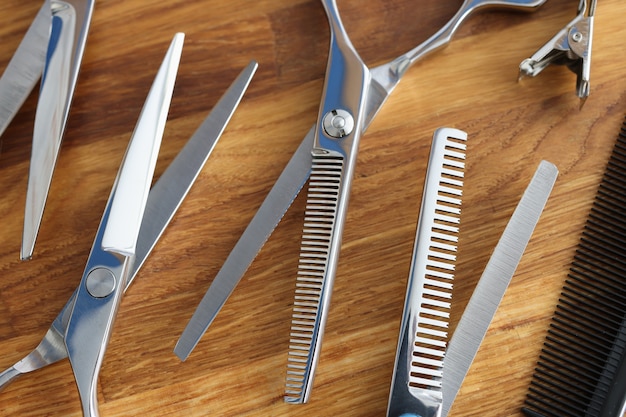 Set of scissors and combs on wooden table closeup