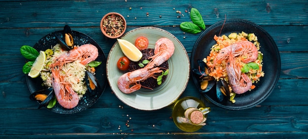 A set of seafood dishes on a blue wooden background Pasta bulgur rice couscous Top view Free space for your text