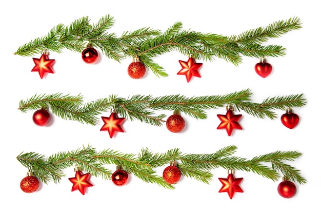 Set of several branches of spruce with Christmas toys on white