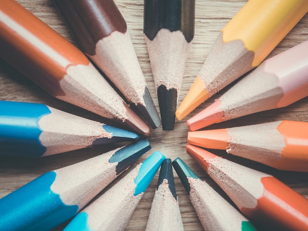 Set of several colored pencils. Pencils in the shape of a circle on a wooden surface.