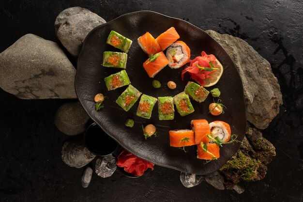 A set of several types of sushi on a beautiful black plate. Japanese dish.