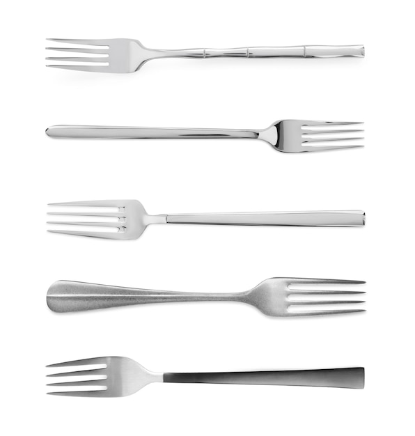 Set of shiny metal forks on white background