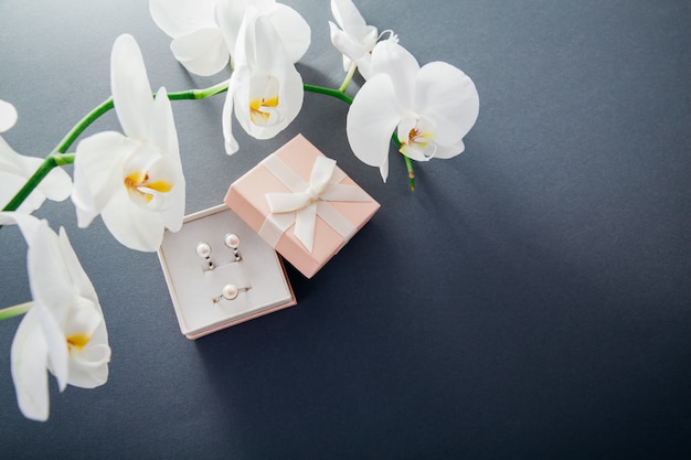 Set of silver ring and earrings with pearls in the gift box with white orchid