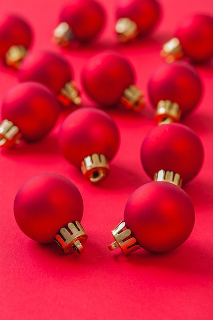 Набор маленьких красных новогодних шаров на красном фоне