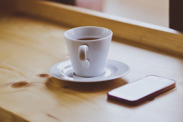 set of smart phone and glasses on wooden desk