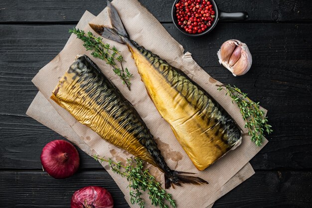 Set of smoked fish mackerel, on black wooden table table, top view flat lay