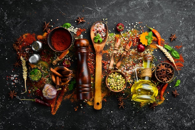 Set of spices and seasonings on a black stone background Top view