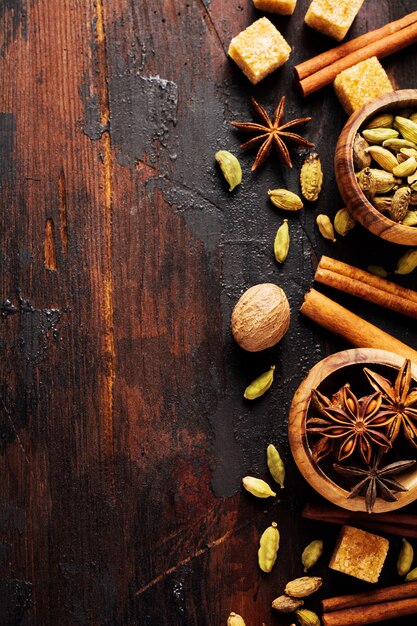 Set of spices of star anise, cardamom, cinnamon and brown sugar on old wooden surface