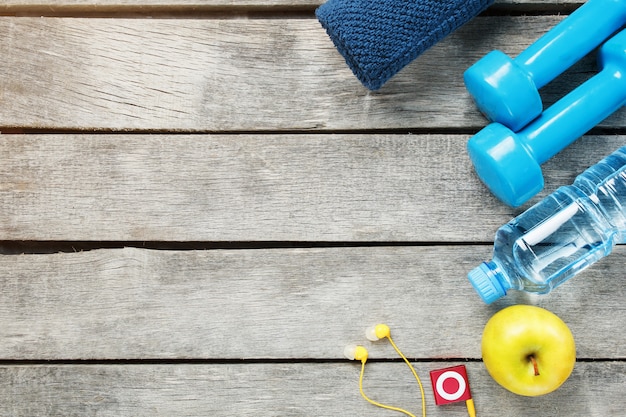 Photo set of sports accessories for fitness  with exercise equipment on gray wooden .