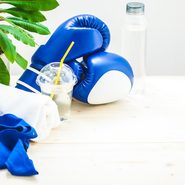 Set for sports, towel, boxing gloves and a bottle of water on a light , healthy lifestyle.