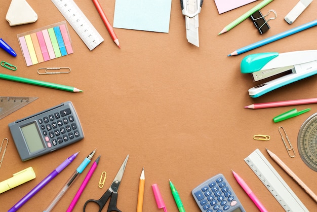 Set of stationery on brown table, top view. School Concept