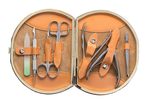 Photo set of steel manicure instruments and tools in orange leather case isolated on white background