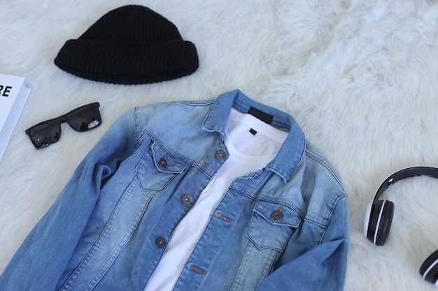 Set of stylish clothes blue denim jacket and white t-shirt with headphone, beanie, and sunglasses