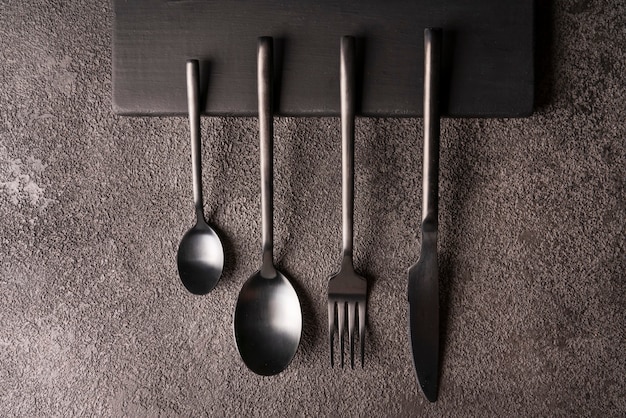 Un set di forchetta cucchiaio coltello posate moderno ed elegante giaceva su uno sfondo di cemento