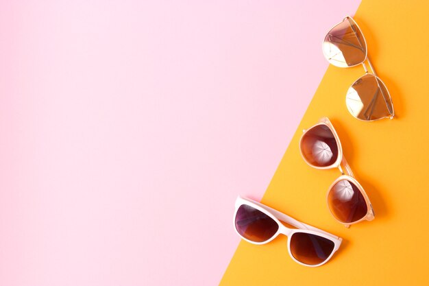 Set of sunglasses on a colored background top view