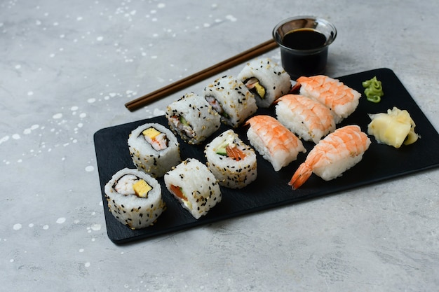 Set sushi en broodjes met zalm en garnalen op een grijze tafel