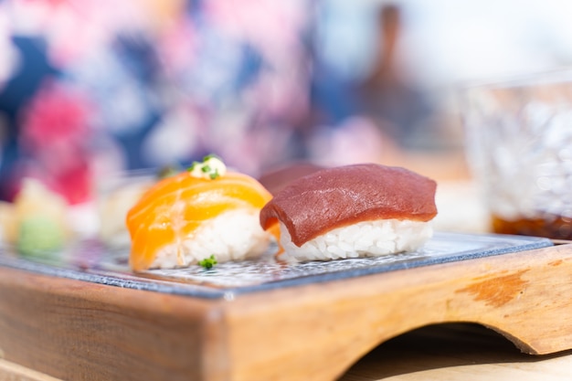 Set sushi eten van tonijn en zalm geserveerd op een houten bordje