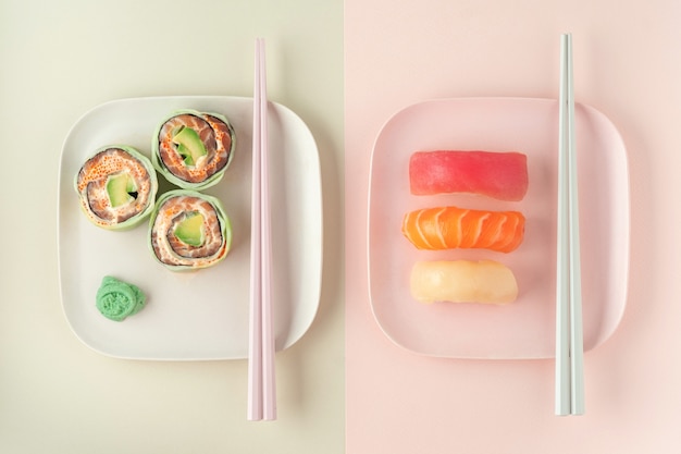 Set of sushi, maki and rolls on colored plates with chopsticks