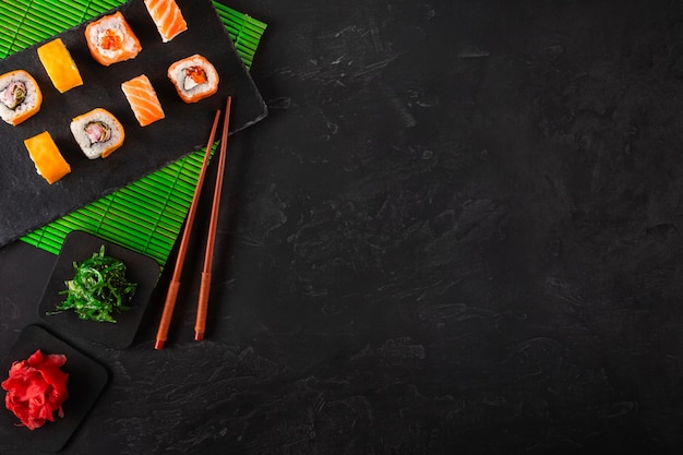 Set of sushi and maki on stone table. 