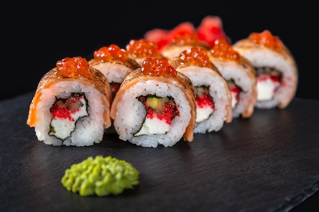 Set of sushi rolls on black background