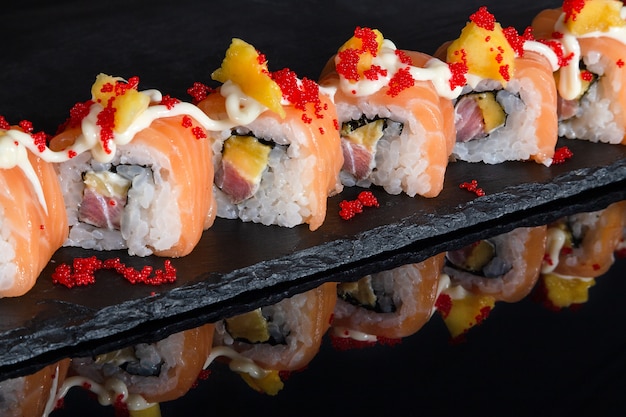 Set of sushi rolls on black desk background