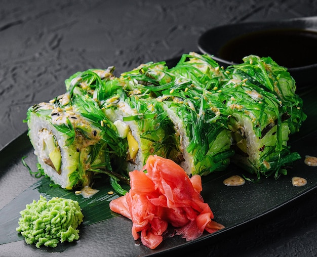 Set sushi rolls in seaweed on black plate