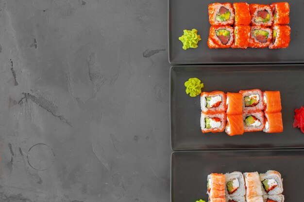 Set of sushi rolls served on gray background