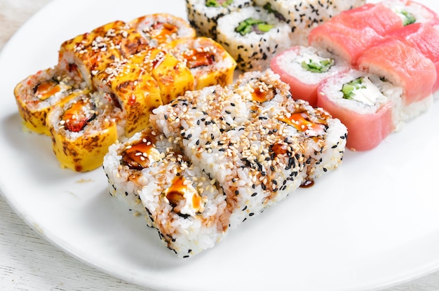 Set sushi rolls with eel sesame avocado and fish Japanese food Top view On a white background