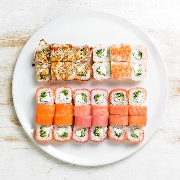 Set sushi rolls with eel sesame avocado and fish Japanese food Top view On a white background