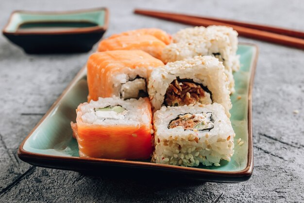 Set of sushi rolls with ginger on a concrete background. Japanese oriental cuisine. Selective focus