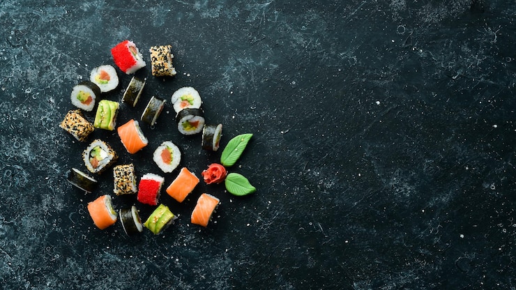 Set of sushi rolls with ginger wasabi and soy sauce on a black stone background Japanese Traditional Cuisine Top view Rustic style