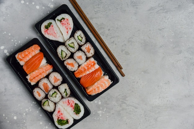 Set of sushi and rolls with salmon and shrimp on a gray table