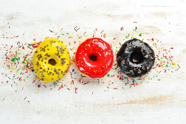 Set of sweet colored donuts on a white wooden background Top view Flat Lay