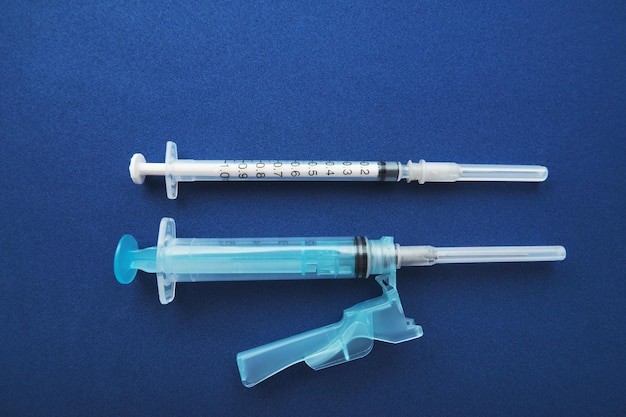 Set of syringes on blue background with copy space