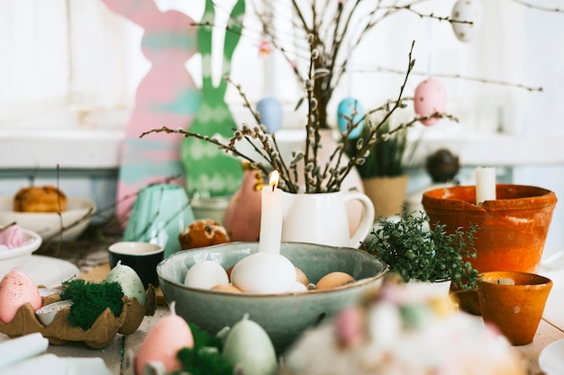 Накрыть стол для пасхальной вечеринки для празднования Счастливой Пасхи в загородном весеннем деревенском стиле