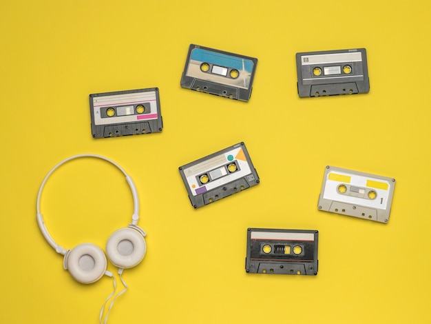 A set of tape recorders and headphones on a yellow surface