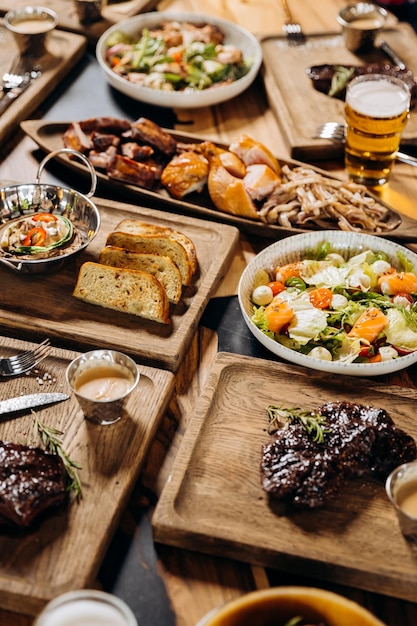 Foto set di gustosi piatti sul tavolo ristorante con insalata di bistecca di manzo e ali di pollo alla griglia concetto di menu piatto